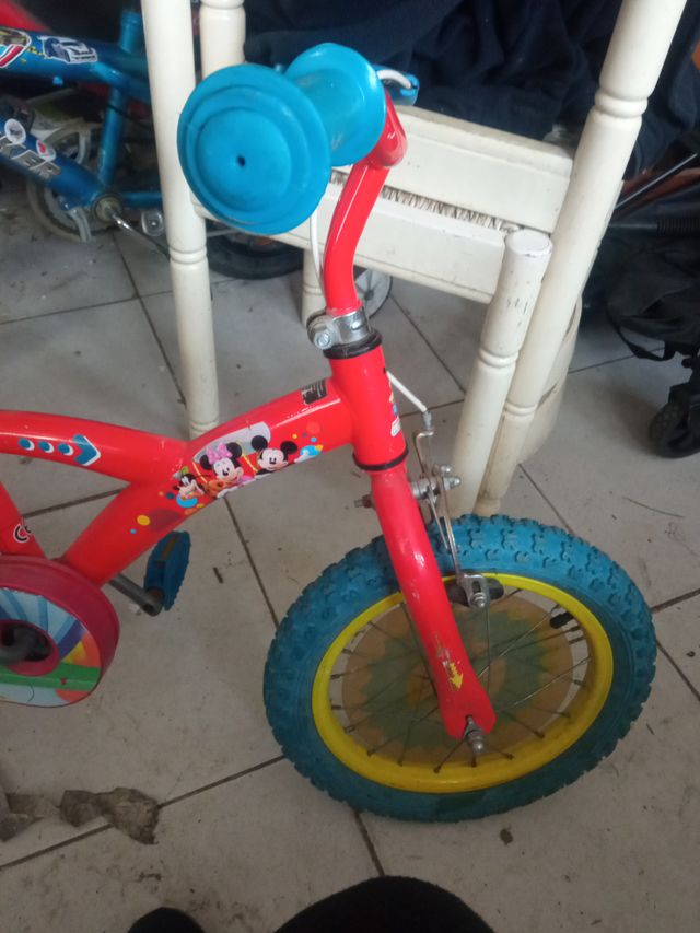 Bicicleta infantil roja con ruedas azules