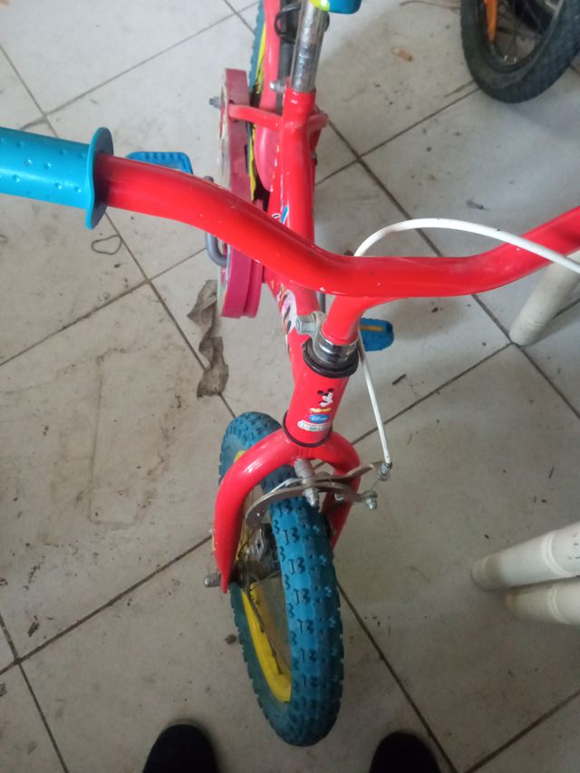 Bicicleta infantil roja con ruedas azules