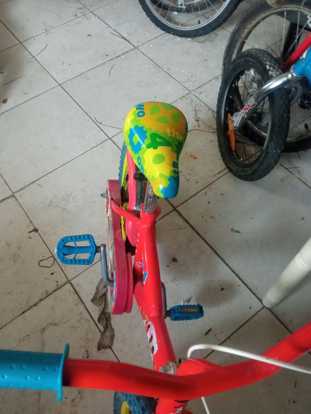 Bicicleta infantil roja con ruedas azules