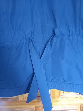 Parka azul marino talla L con cinturón ajustable.