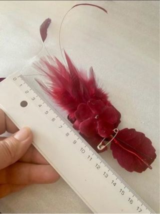 Broche ceremonia plumas burdeos