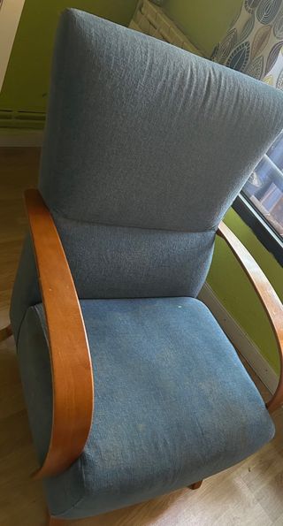 Sillón tapizado azul con brazos de madera