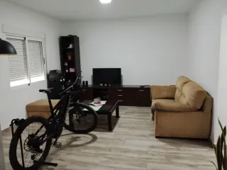Comedor madera bien cuidado dos sofás y un puff