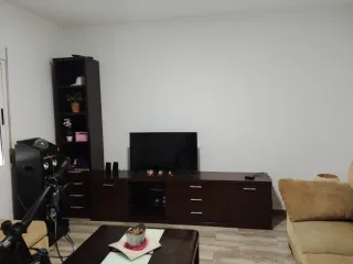 Comedor madera bien cuidado dos sofás y un puff