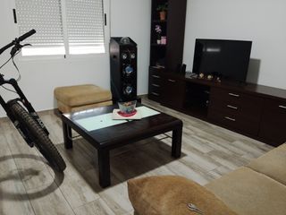 Comedor madera bien cuidado dos sofás y un puff