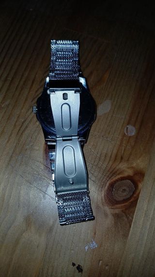 Reloj plateado con incrustaciones
