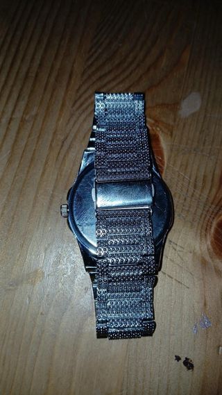 Reloj plateado con incrustaciones