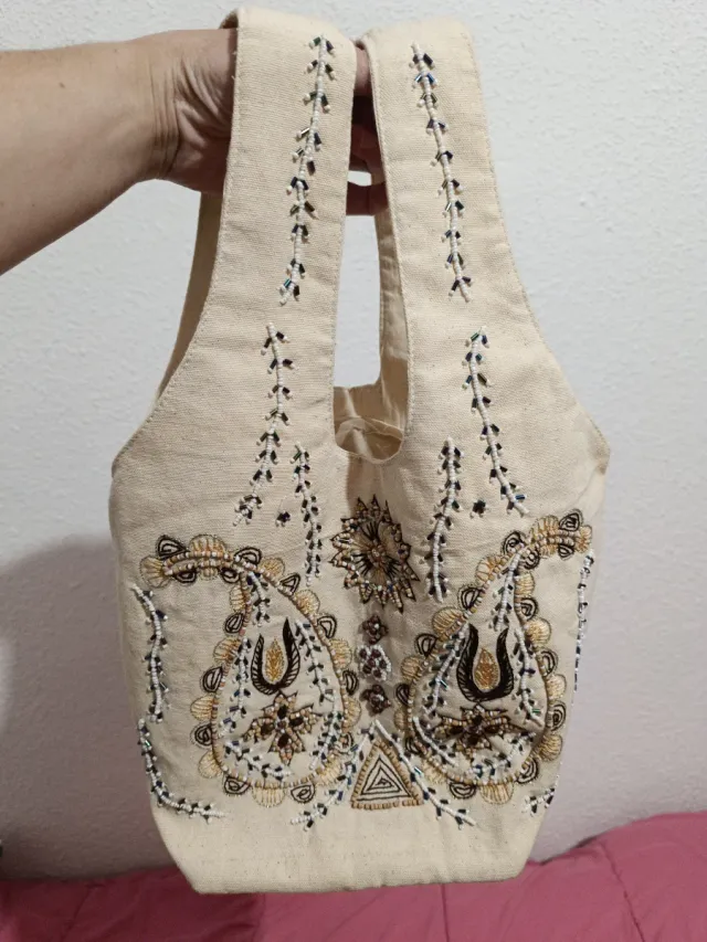 Dos bolsos con pedrería beige y negro