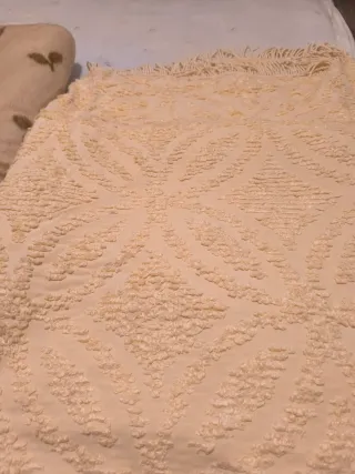 Manta, colcha y una toalla de ducha sin estrenar.