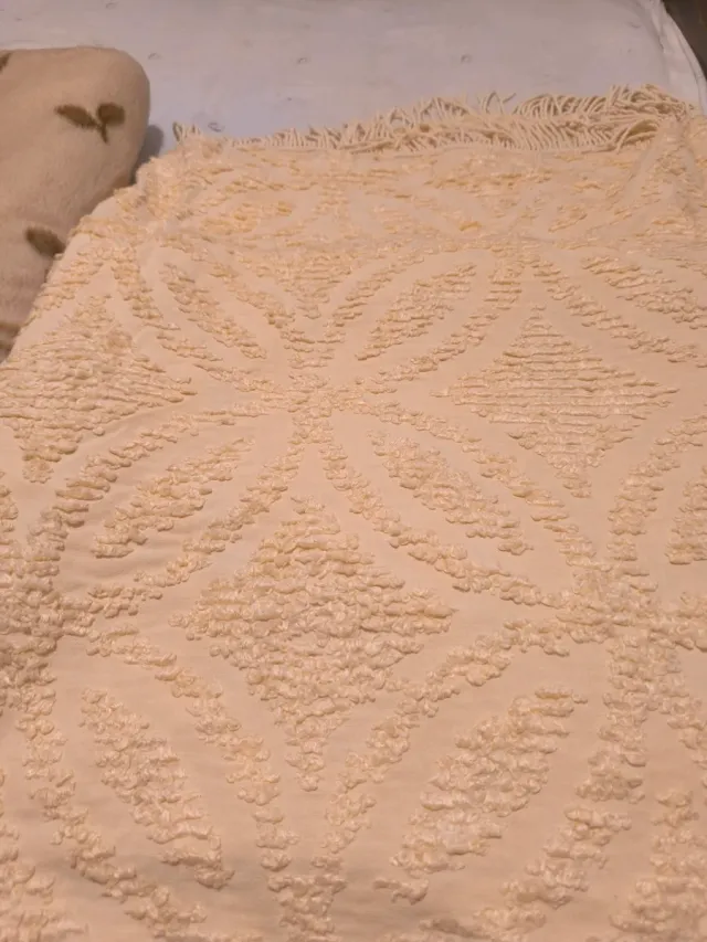 Manta, colcha y una toalla de ducha sin estrenar.