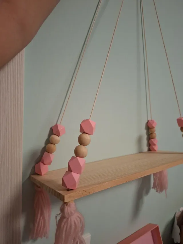 Estantería de madera con cuentas y borlas