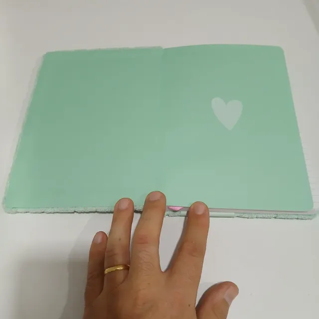 Bloco de notas verde com corações