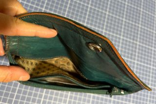 Cartera de piel verde con adornos dorados