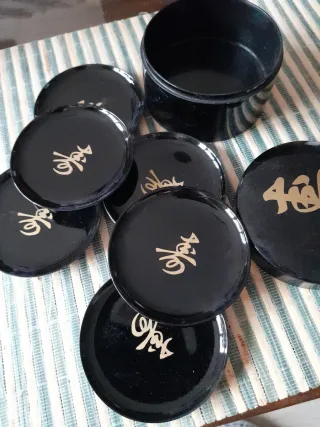 Posavasos negro con diseño dorado