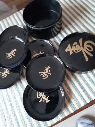 Posavasos negro con diseño dorado