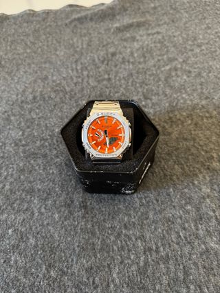 Reloj Casio plateado con dial naranja 