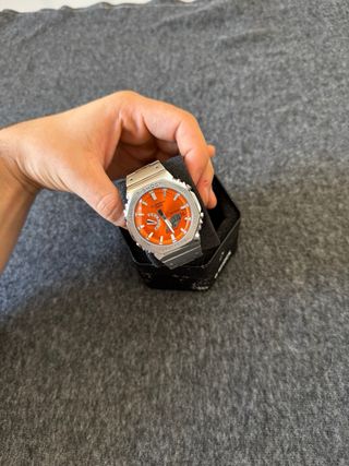 Reloj Casio plateado con dial naranja 