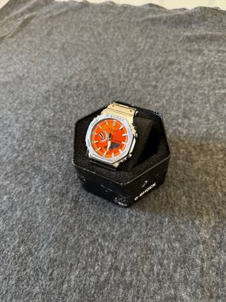 Reloj Casio plateado con dial naranja 