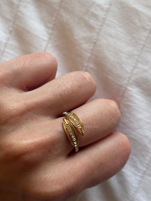 Anillo de plumas dorado con piedras plateadas