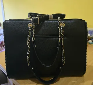 Bolso de mano negro con tachuelas y cadena