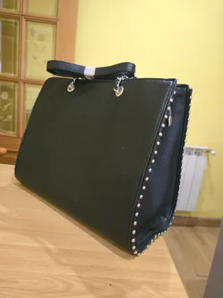 Bolso de mano negro con tachuelas y cadena