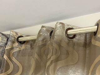 Cortinas beige y doradas con barra