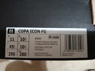Botas de fútbol Adidas blancas y negras.