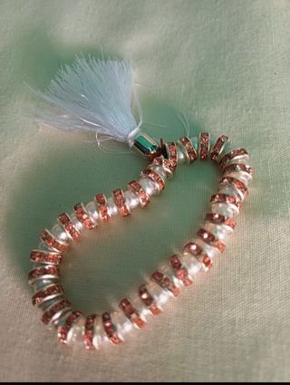 Pulsera elástica con perlas y detalles rosas