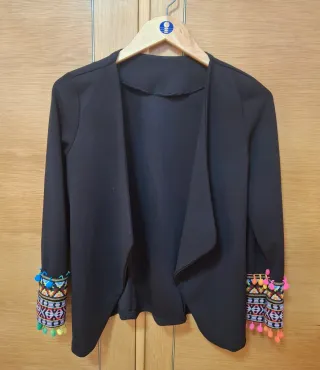 Americana negra con detalle de pompones