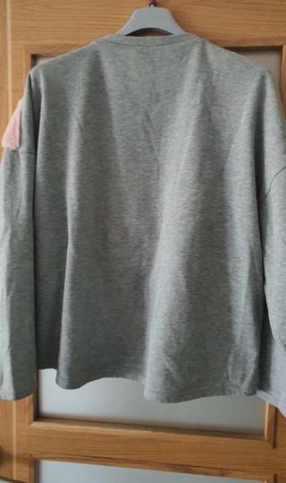 Sudadera gris con detalle peluche V rosa