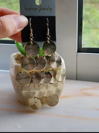 Brincos dourados em forma de discos