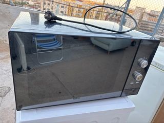 Microondas plateado con puerta de cristal