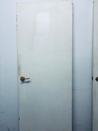 Puerta de madera blanca con pomo dorado