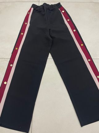 Pantaloni neri con bottoni laterali rossi