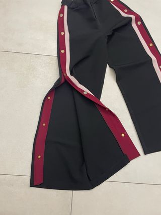 Pantaloni neri con bottoni laterali rossi