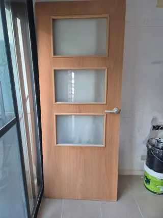 Puerta madera acristalada, recogida en Terrassa