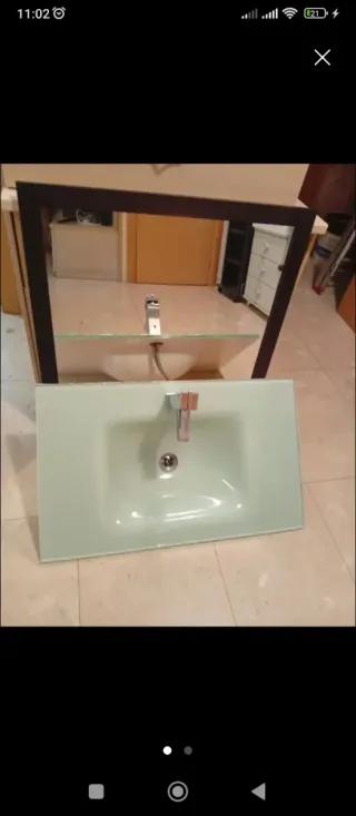 Pica de baño de cristal verdoso con espejo.