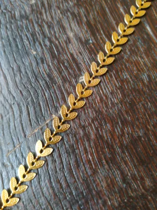 Cadena de acero dorada con diseño de espiga.