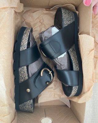 Sandalias Panama Jack negras con hebilla dorada