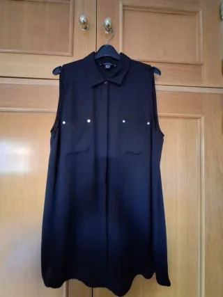 -Camisa negra sin mangas con tachuelas.