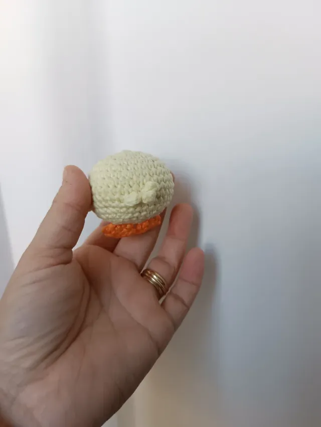 Pollito tejido a mano con gorritos.