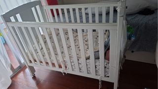 Cuna de madera blanca con ruedas