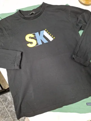 Camiseta verde con estampado y negra también.