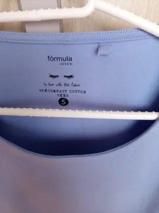 Camiseta azul con botones dorados