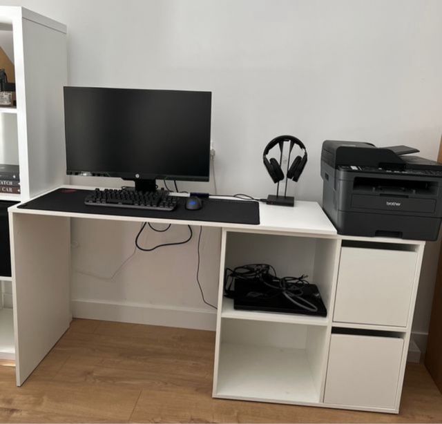 Escritorio blanco de madera con cubículos.