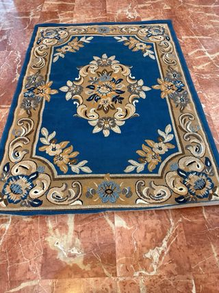 Alfombra grande azul y marrón con diseño floral 