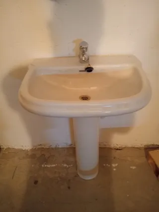 Lavabo de porcelana blanco con grifo.