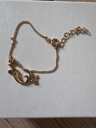 Pulsera dorada con diseño de gato