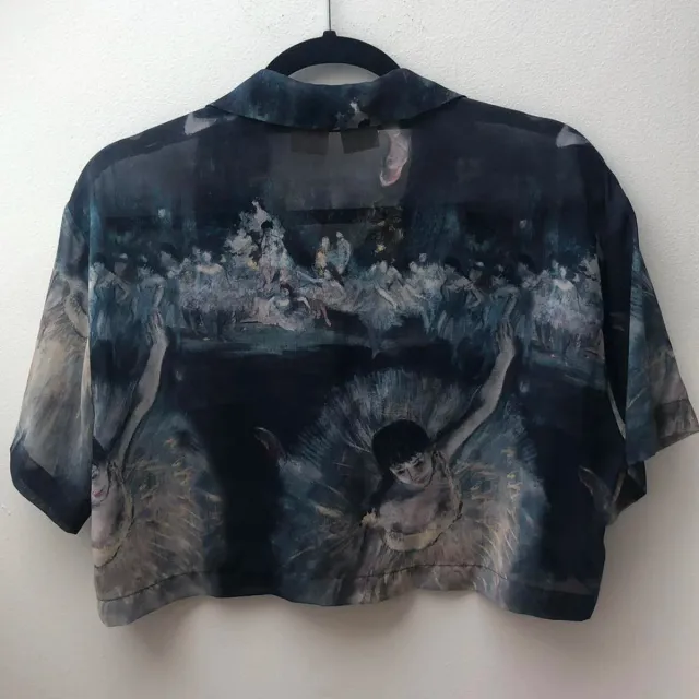 Blusa azul corta con estampado de bailarinas.