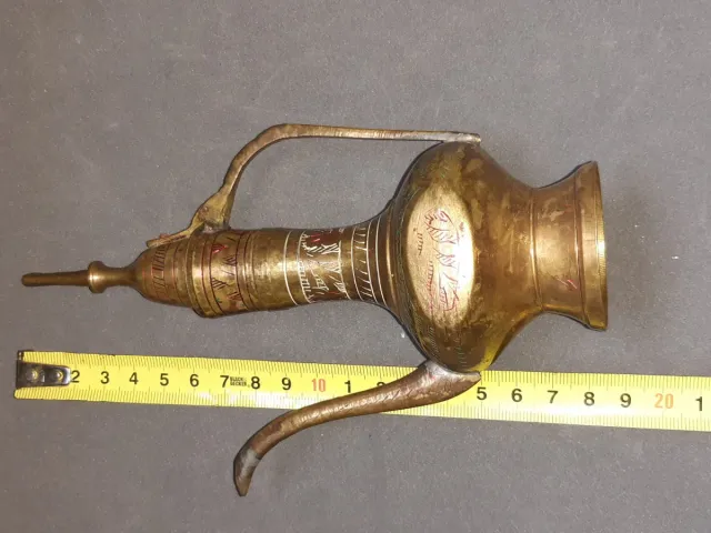 Jarra de metal dorada con detalles rojos